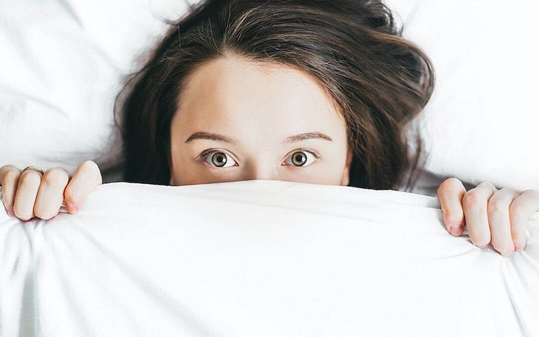 respiração e sono woman covering her face with blanket